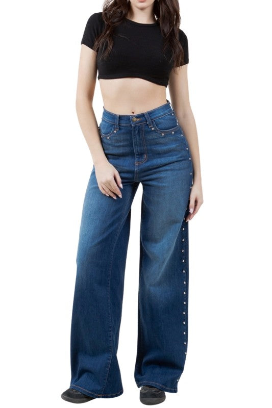 Person wearing blue jeans and a black top on a white background