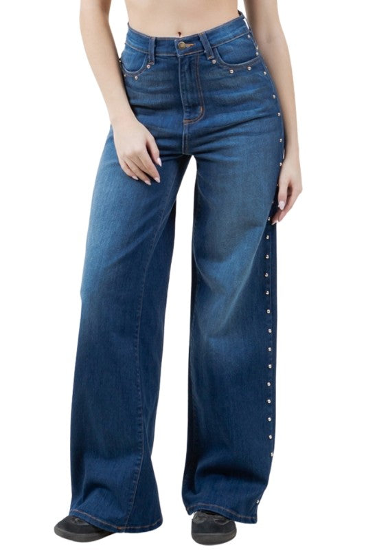Blue jeans with decorative studs on a white background