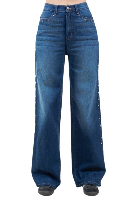Blue jeans with decorative studs on a white background