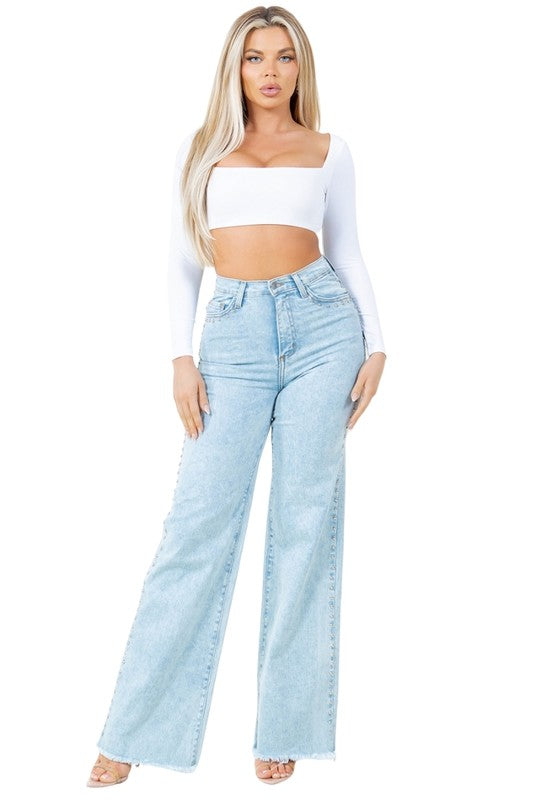 Woman wearing a white top and light blue jeans on a white background
