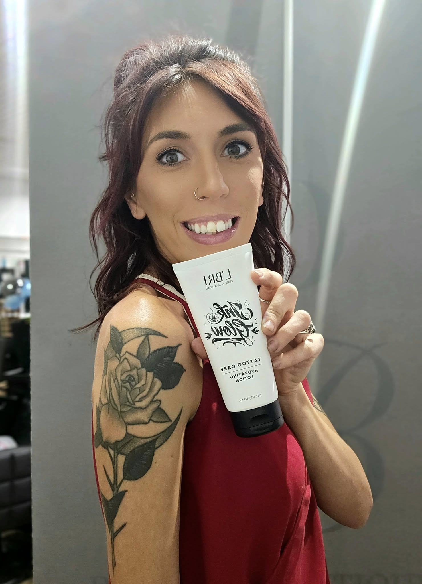 Woman holding a product with visible branding against a neutral background