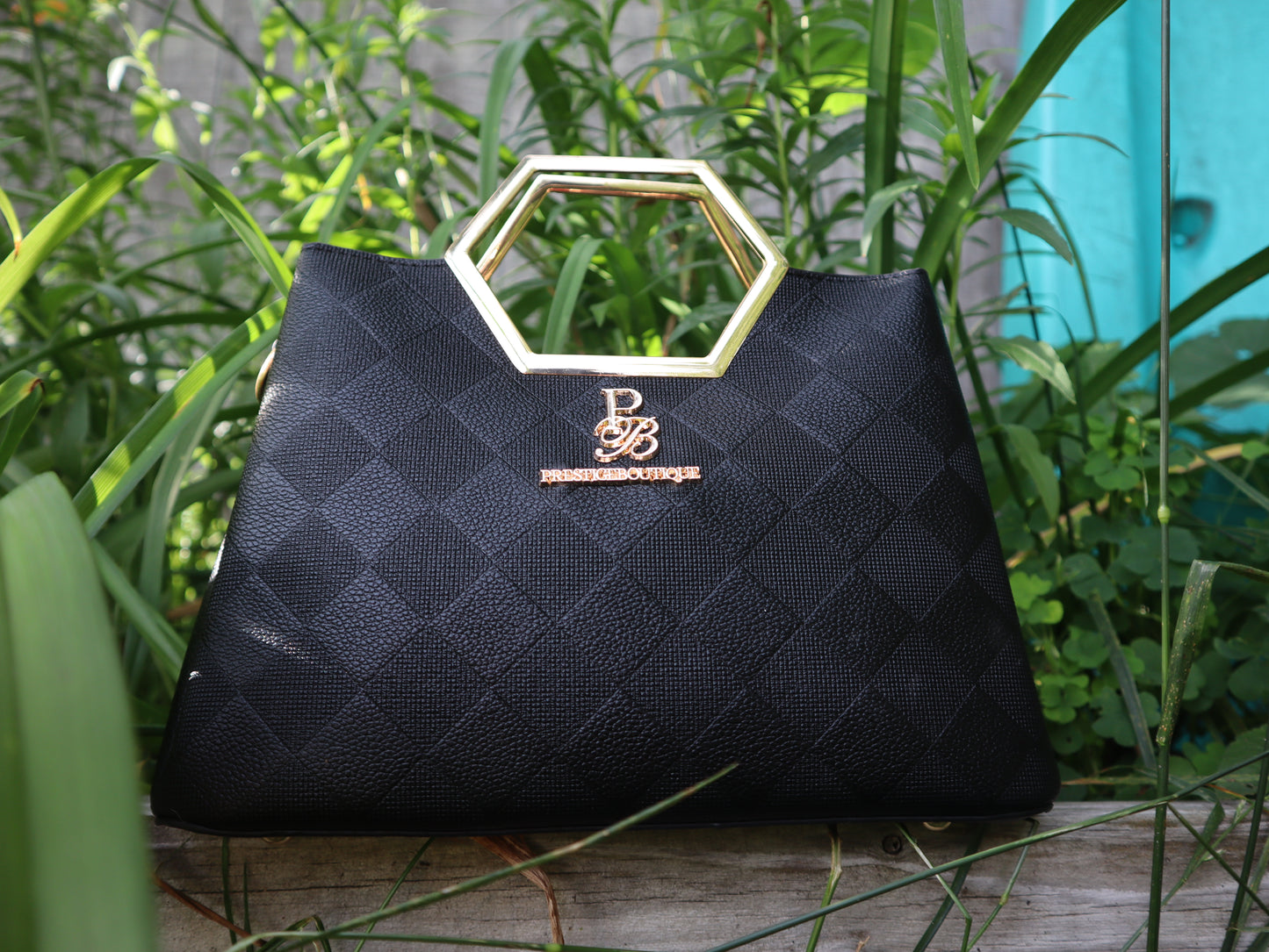 Make a fearless statement with The Hex Appeal Prestige Boutique Crossbody Handbag. This daring accessory combines high-end sophistication with practical design. Its large capacity and secure zipper keep your essentials safe while making a bold statement wherever you go. Perfect for those who refuse to blend in. In black and gold. Timeless style. elegant. Staple piece