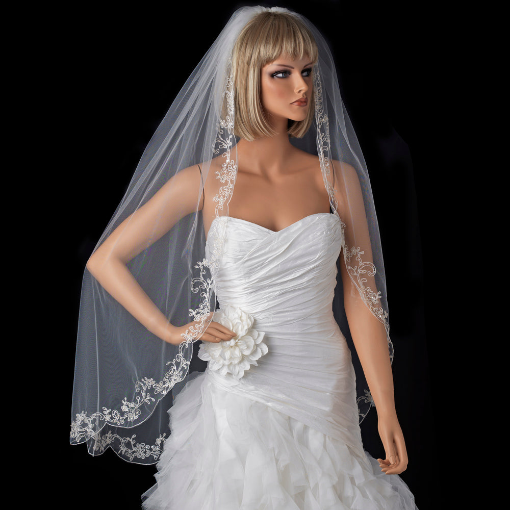 Bridal single-layer waltz-length veil with couture embroidery displayed on a mannequin wearing a wedding dress.