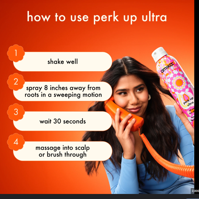 Person holding a phone with a hair product bottle, instructions on how to use 'perk up ultra' displayed.