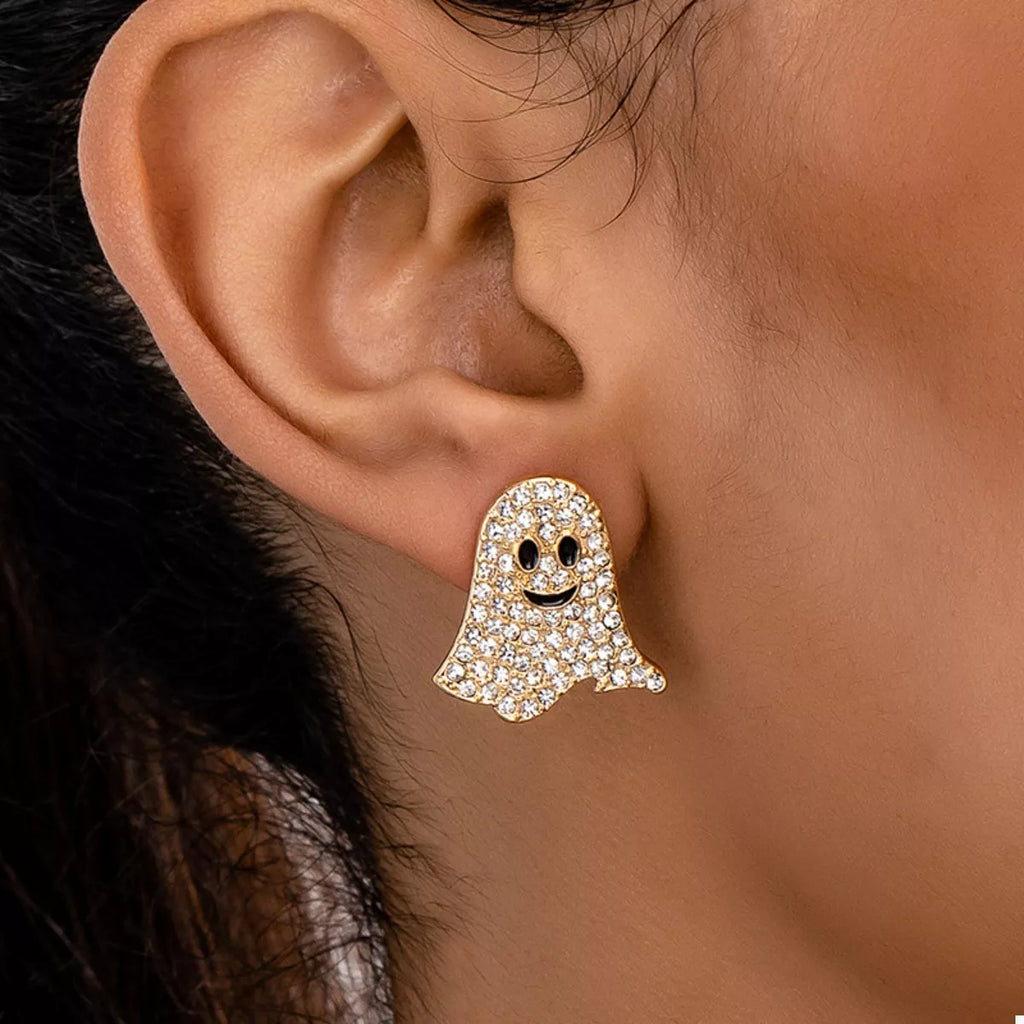 Gold ghost-shaped earring worn on an ear