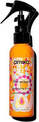 A bottle of 'The Wizard' detangling spray by Amika, with a orange label and black spray nozzle.
