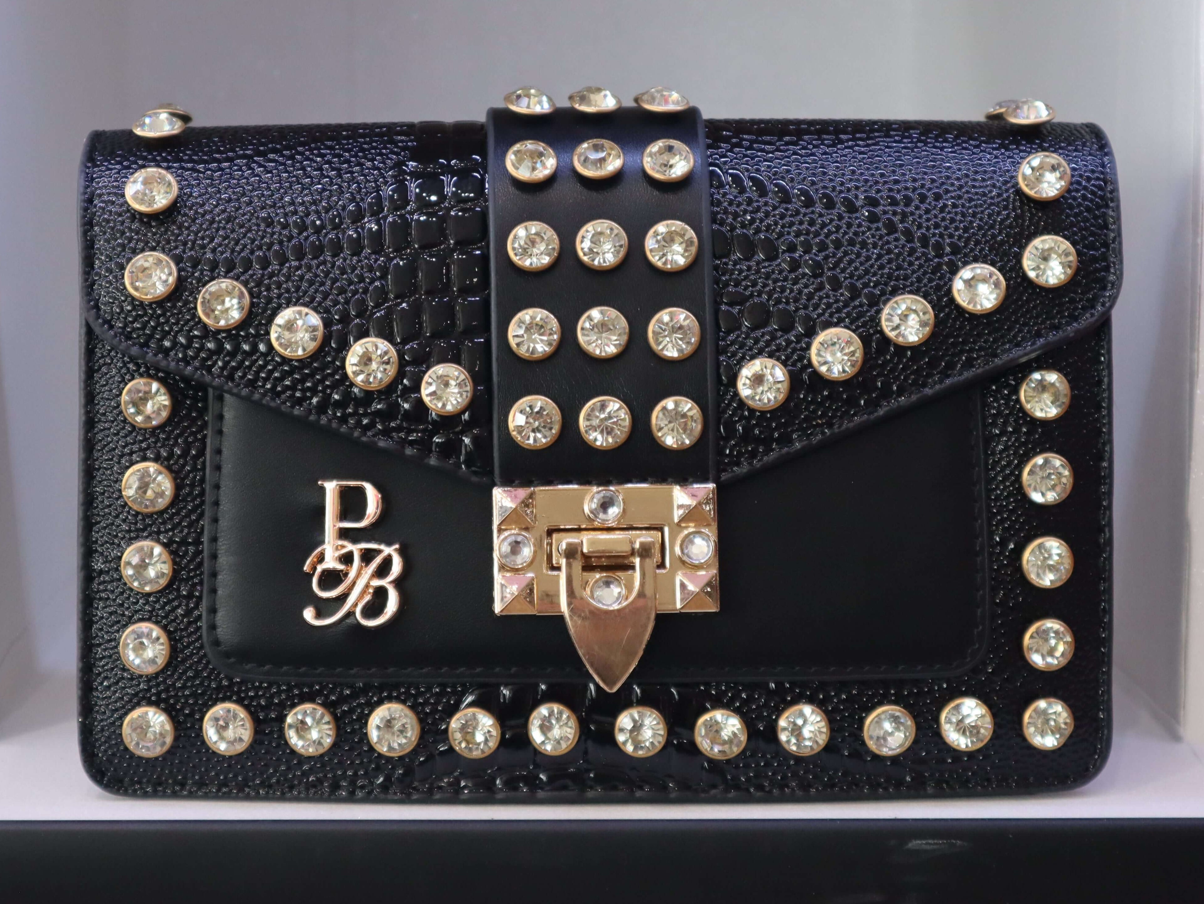 Black studded handbag with a brand logo on a white background