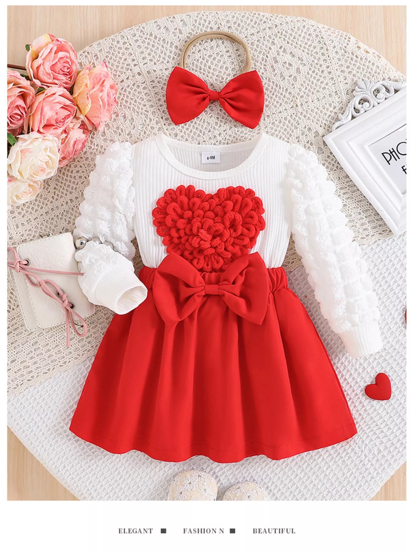 Children's outfit with red and white dress and headband on a textured surface with flowers.