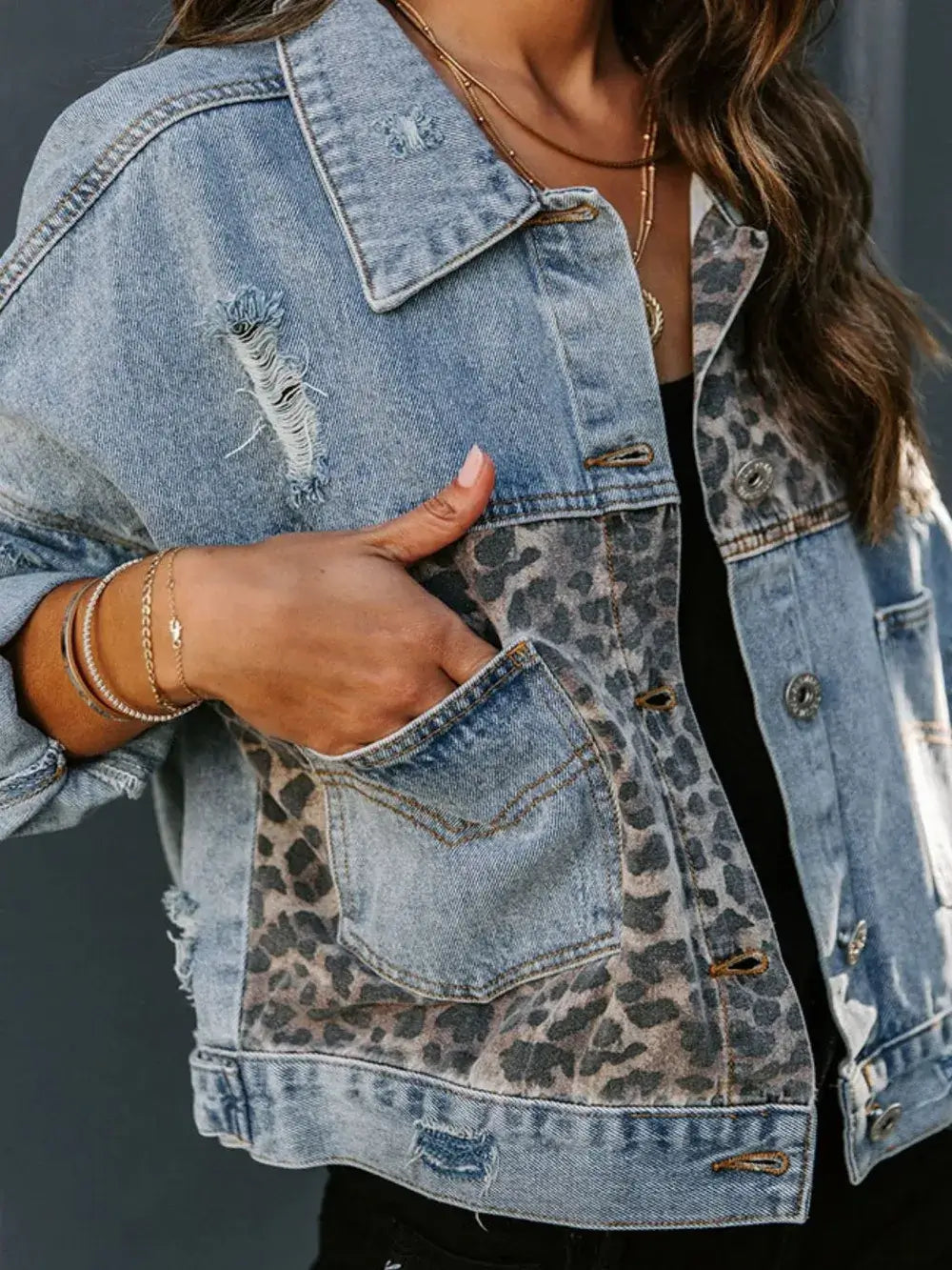 Denim jacket with leopard print pocket on a dark background