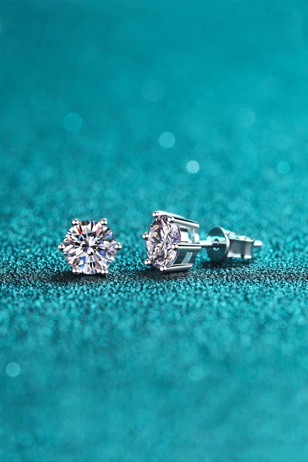 Endless Cheer Moissanite Stud Earrings .2 Carat Silver stud earrings with clear gemstones on a teal background