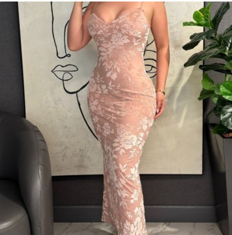 Person wearing a pink lace dress in an indoor setting with a minimalistic wall art background.