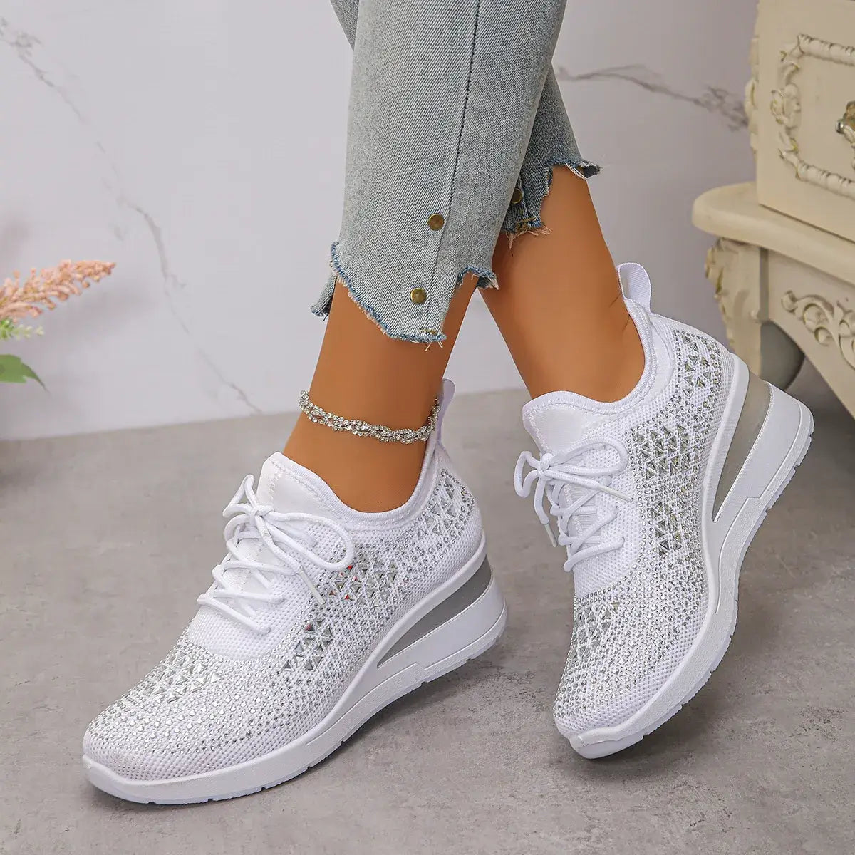 White sneakers with lace-up design worn by a person on a neutral background
