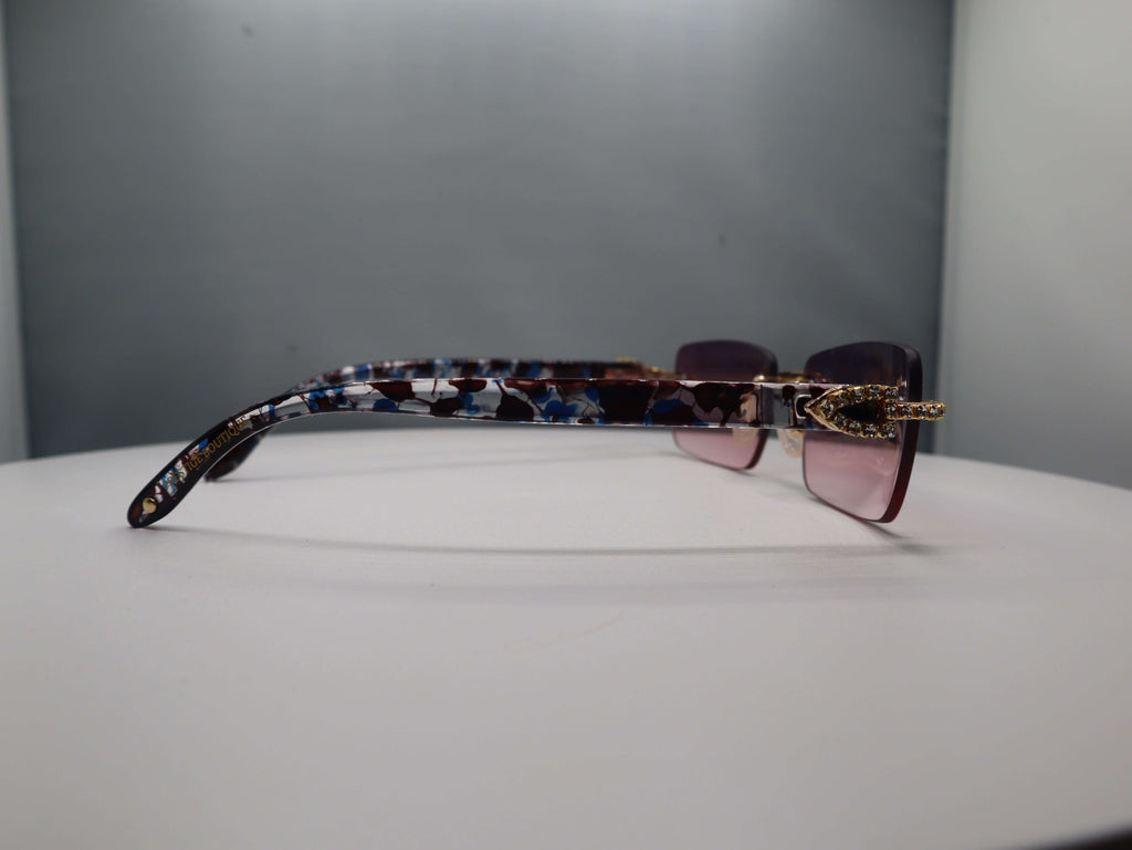 Side view of Prestige Boutique Pink Floral Fashionista sunglasses showcasing black, blue, and gold patterned arms.