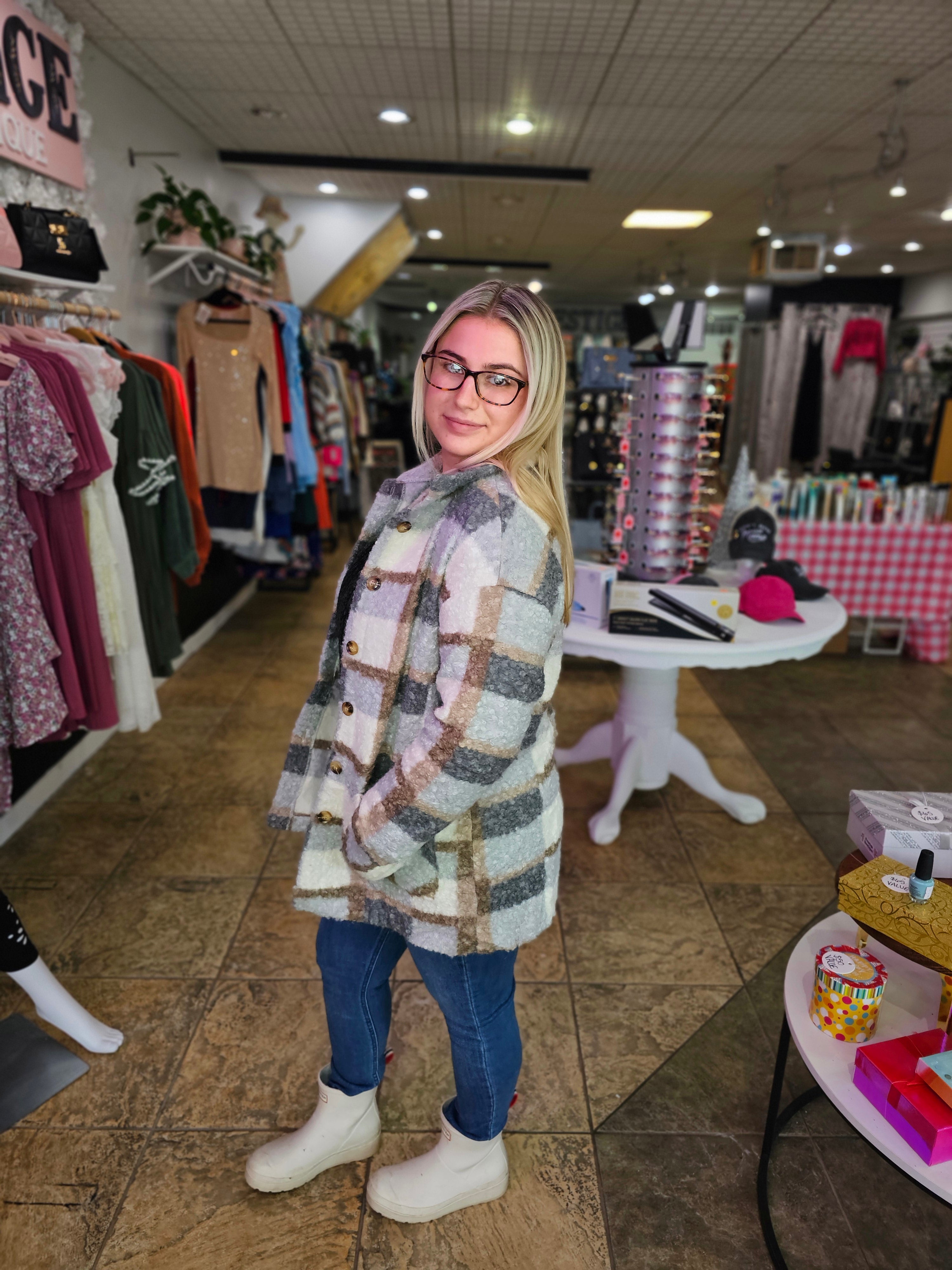 Plaid Woolen Coat worn by a model in a trendy store, showcasing its stylish plaid pattern and cozy design.