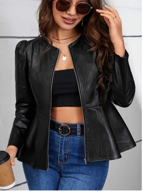 Woman wearing a black leather jacket, black top, and blue jeans against a gray background