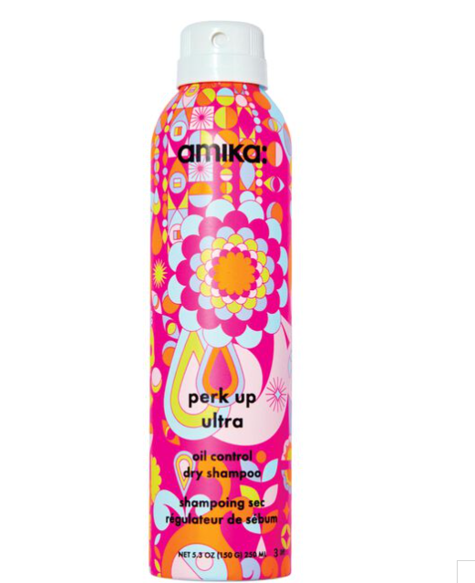 A bottle of Amika Perk Up Ultra Oil Control Dry Shampoo with a colorful pattern design.