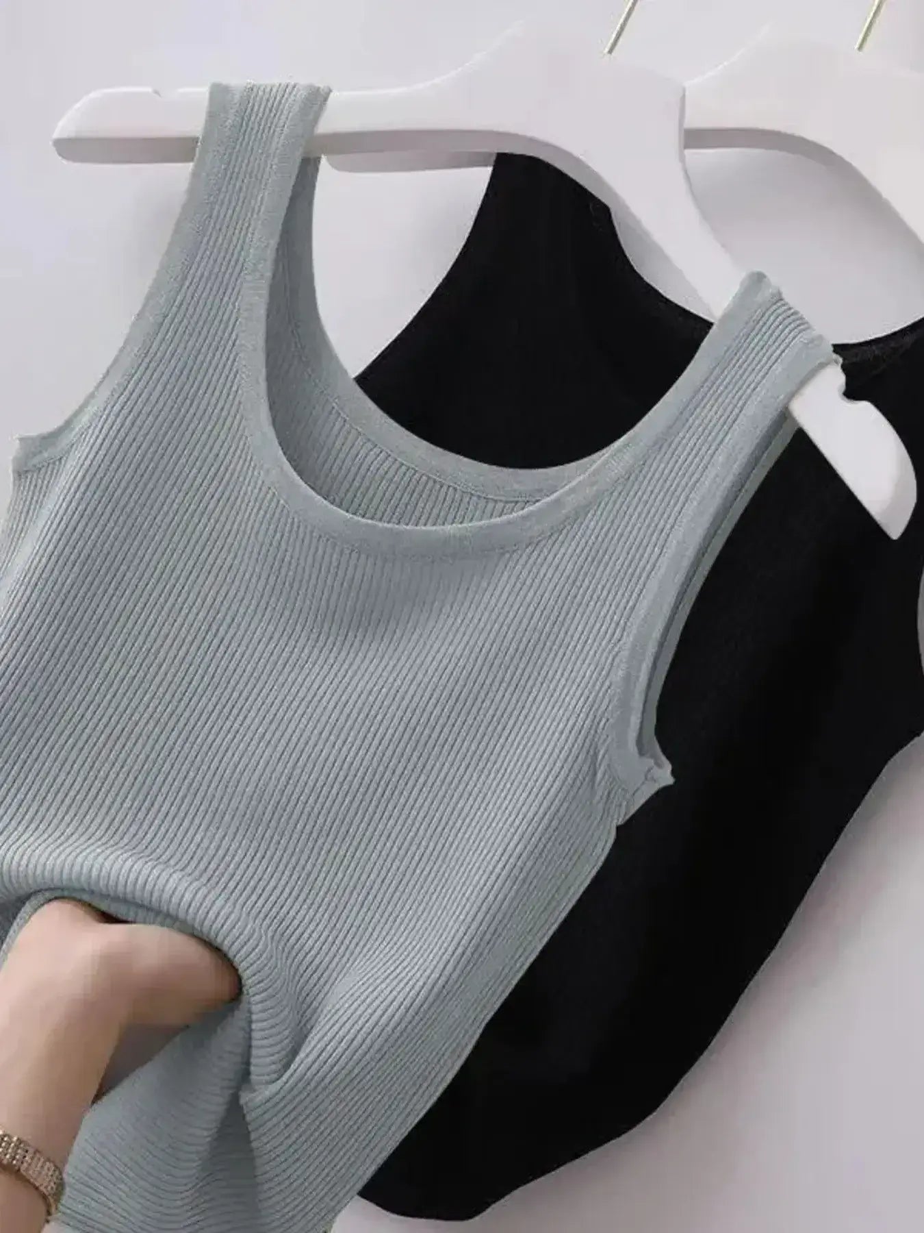 Gray tank top on a hanger against a white background