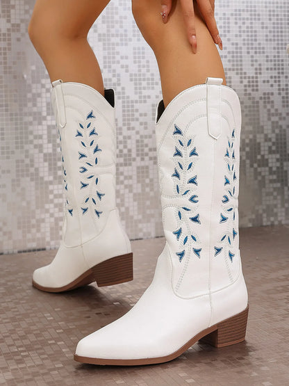 White cowgirl boots with embroidered details, featuring a pointed toe and block heel for stylish comfort.