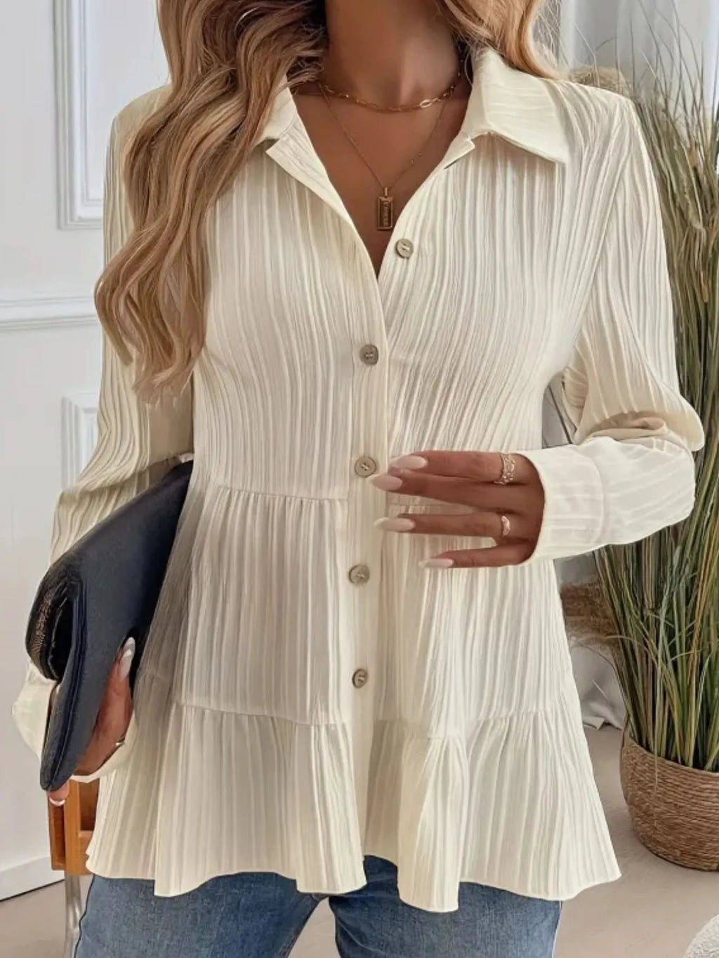 Woman wearing a cream-colored button-up dress with a blurred background