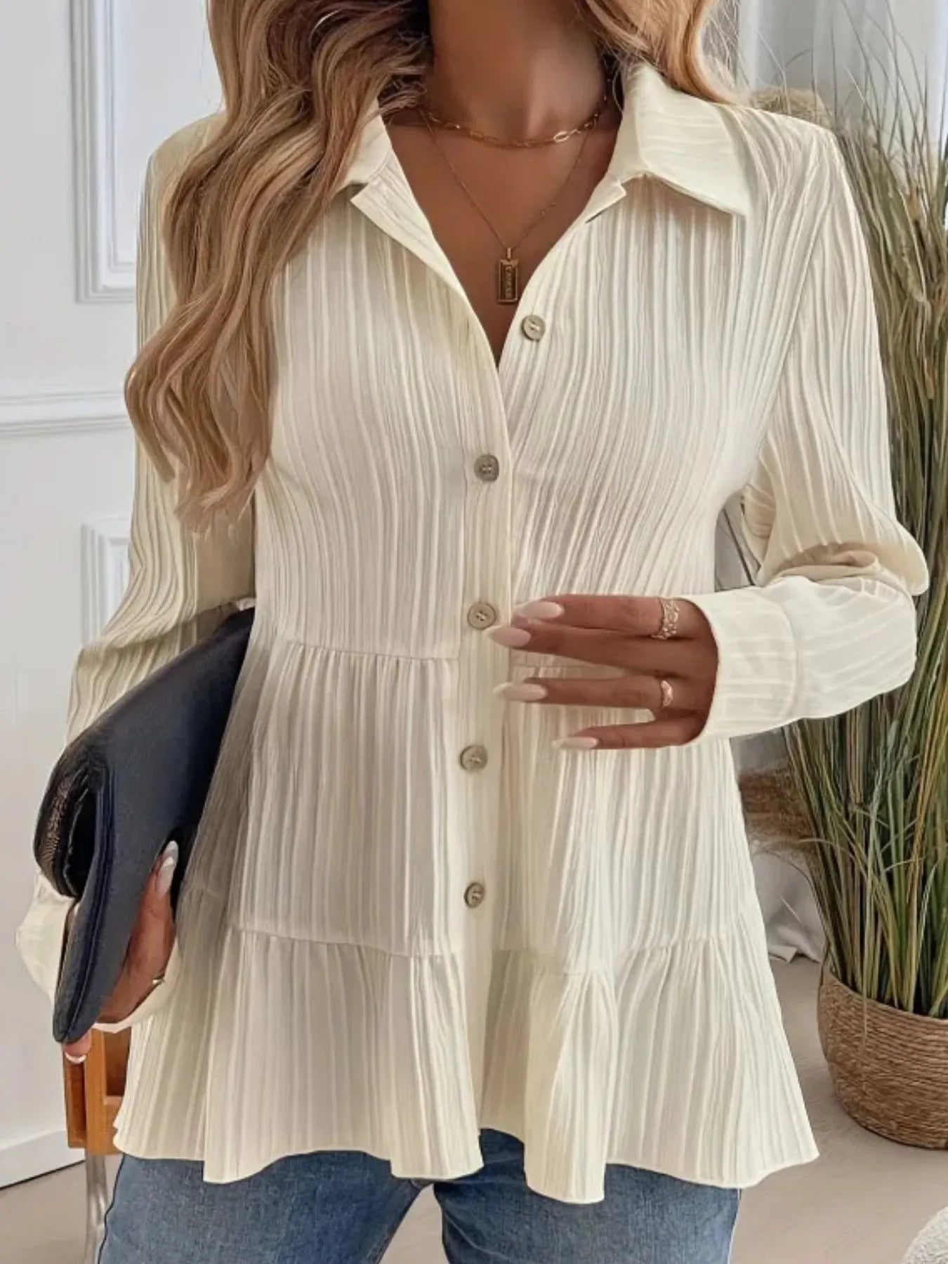 Woman wearing a cream-colored button-up dress with a blurred background