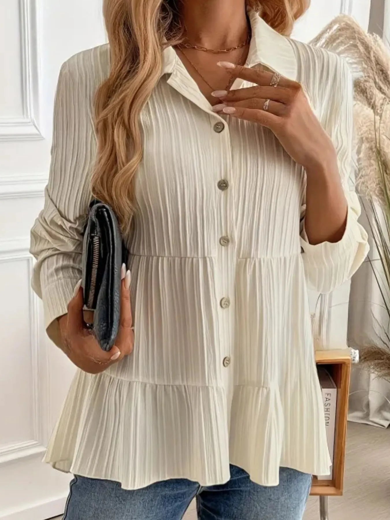 Woman wearing a white tiered blouse with a blurred indoor background
