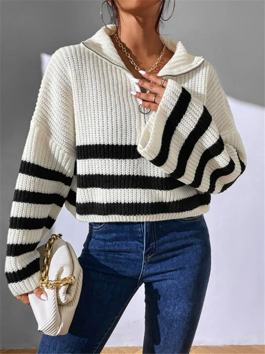 Person wearing a white and black striped sweater with blue jeans against a neutral background