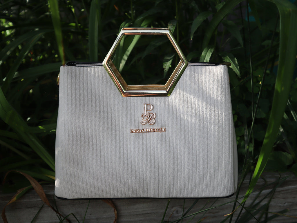 Make a fearless statement with The Hex Appeal Prestige Boutique Crossbody Handbag. This daring accessory combines high-end sophistication with practical design. Its large capacity and secure zipper keep your essentials safe while making a bold statement wherever you go. Perfect for those who refuse to blend in. white and gold. Business casual. Purse. Bold style. Outfit Inspo