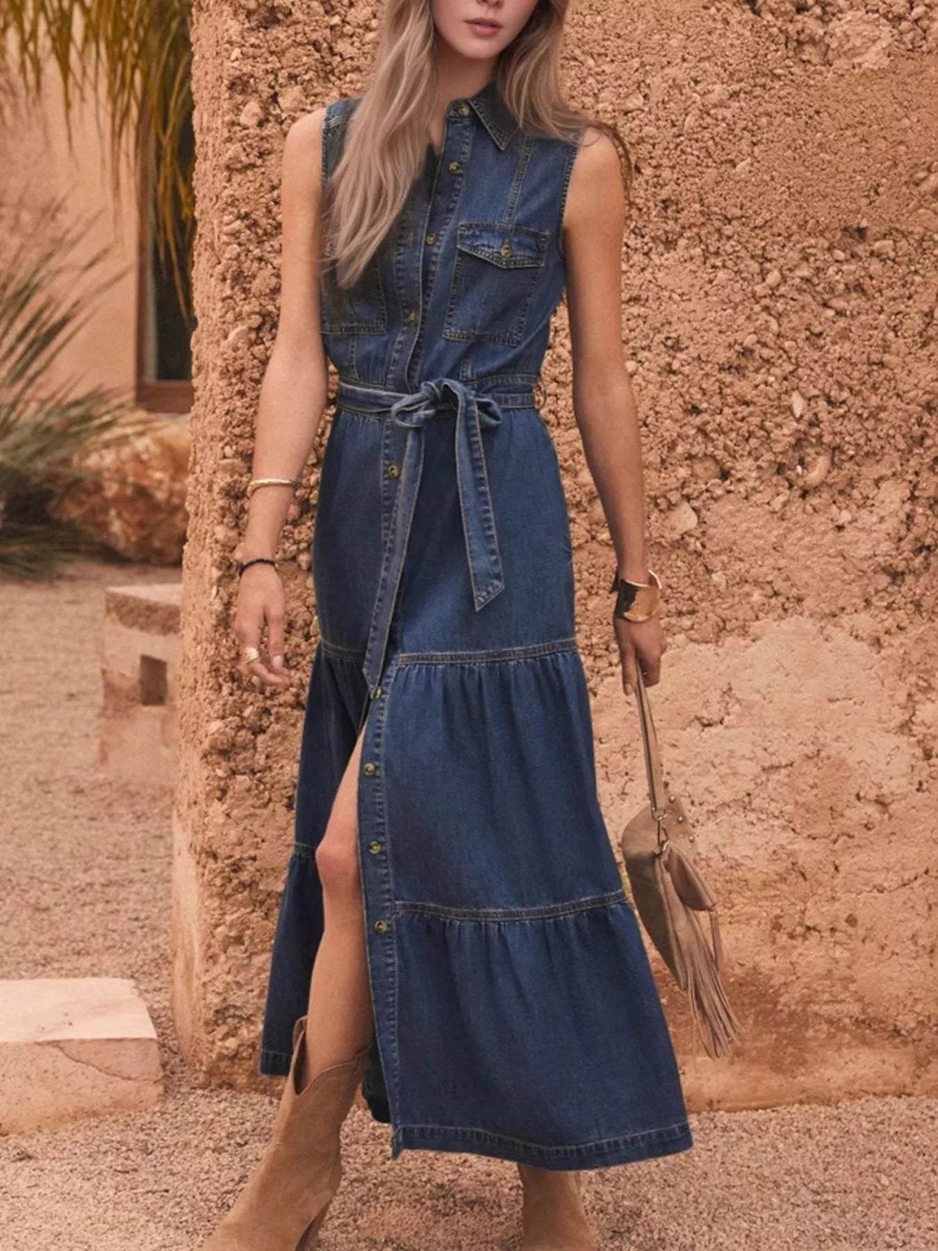 Woman wearing a denim dress with a stone wall background