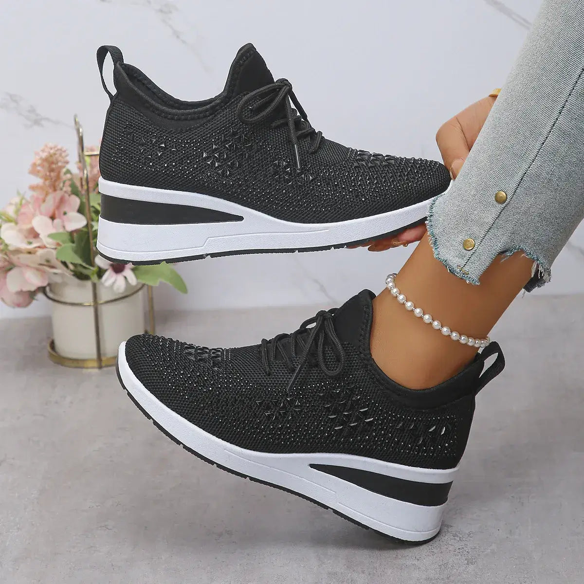 Black and white sneakers worn by a person with a blurred background