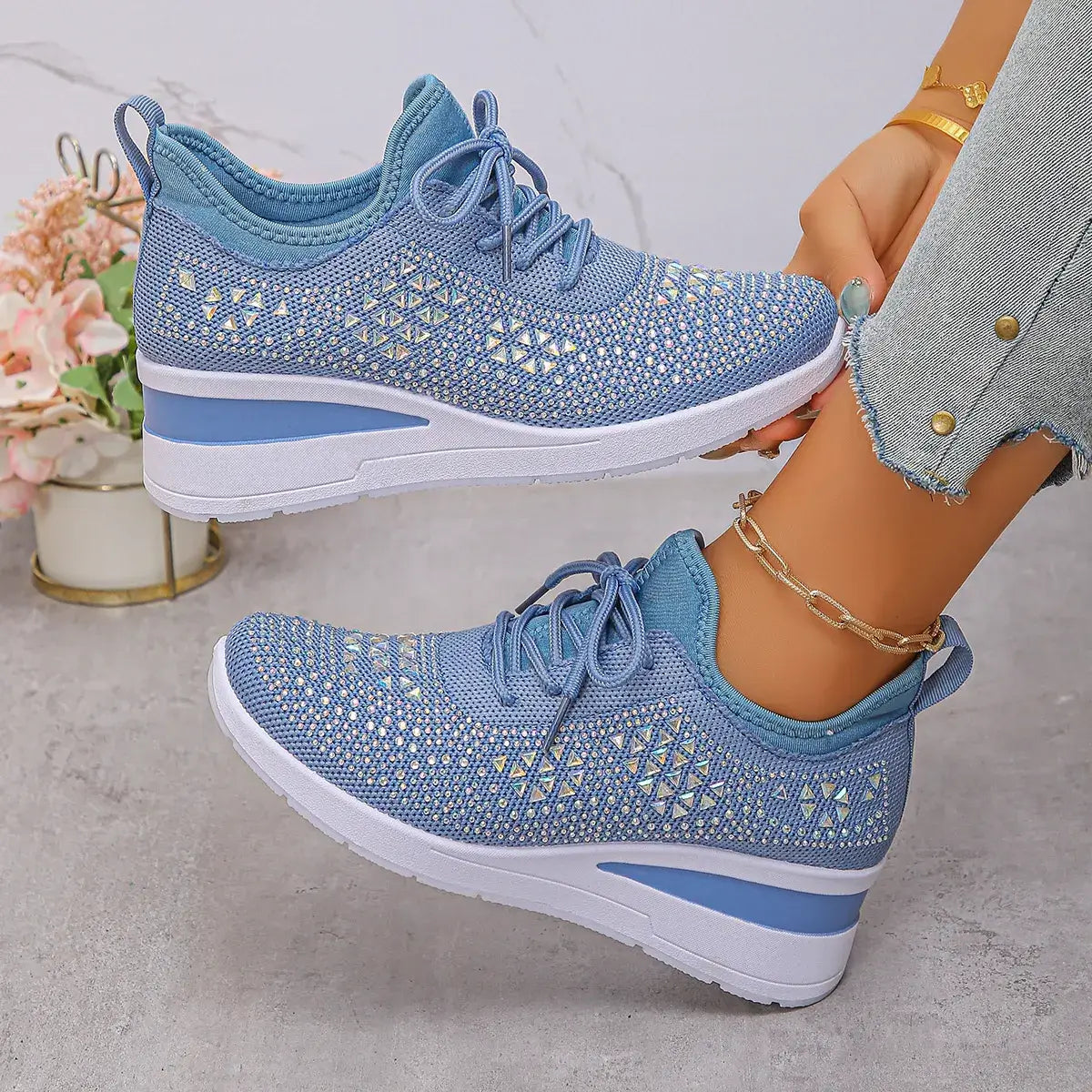 Blue patterned sneakers worn by a person on a light gray background
