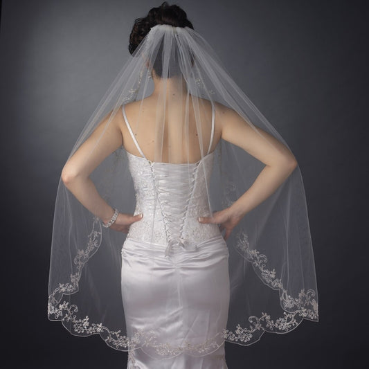 Bridal wedding veil with couture embroidery, single-layer waltz length, elegantly draping behind a bride.