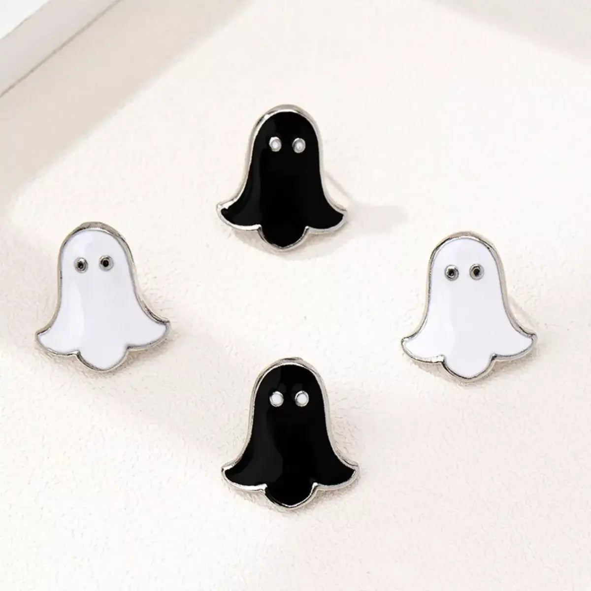 Four ghost-shaped earrings on a white background