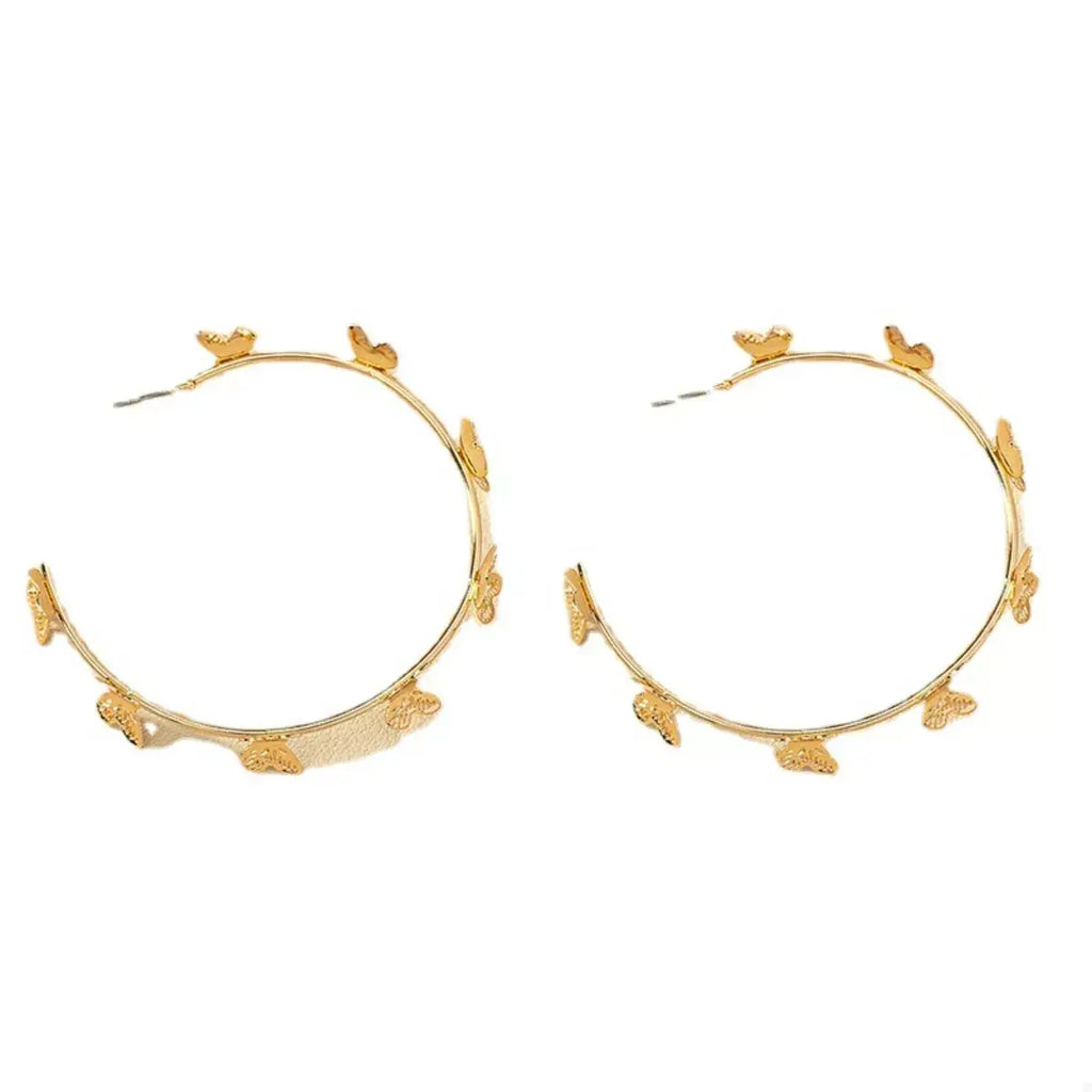 Gold hoop earrings with floral designs on a white background