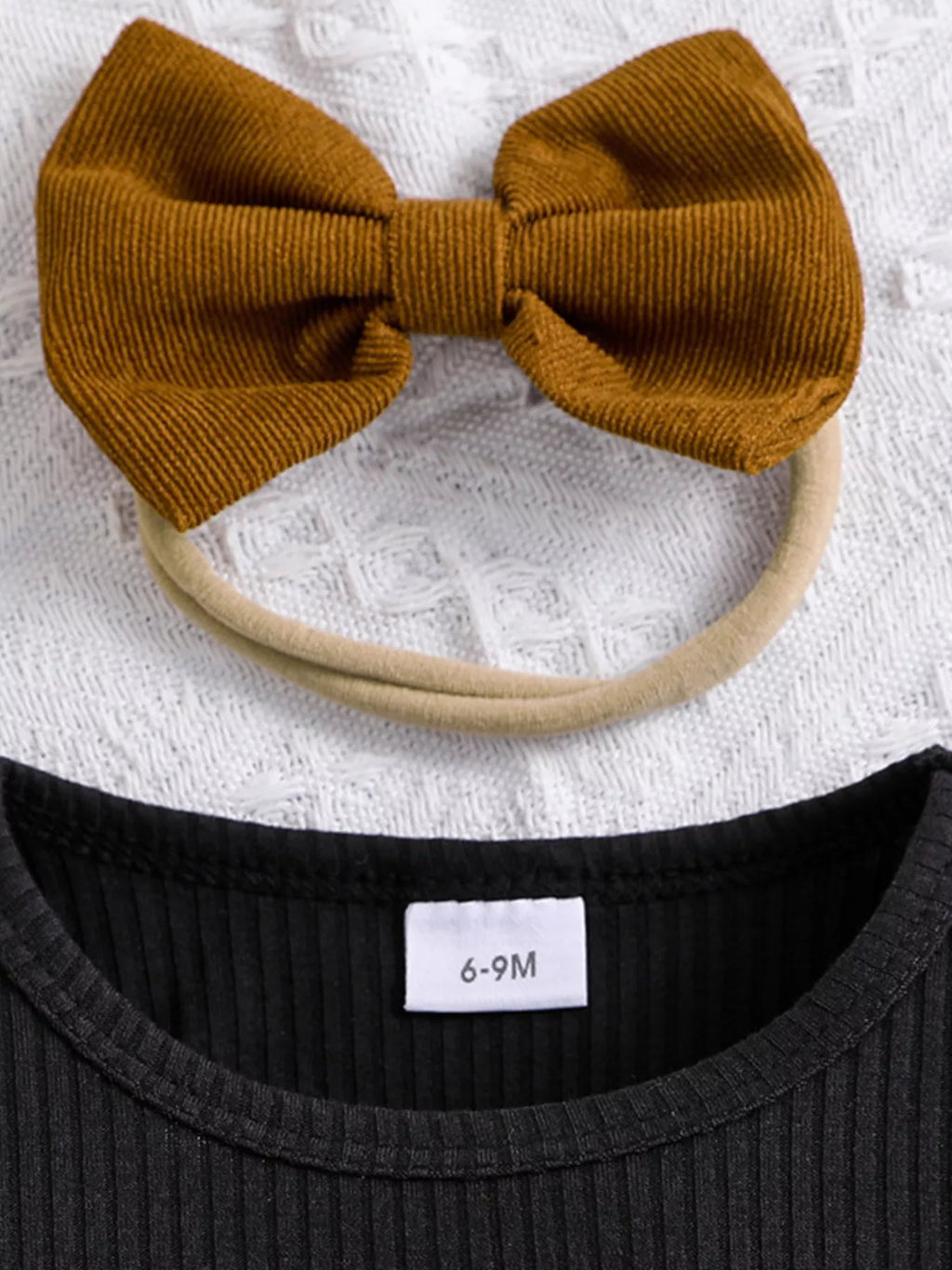 Brown bow headband on a textured white background