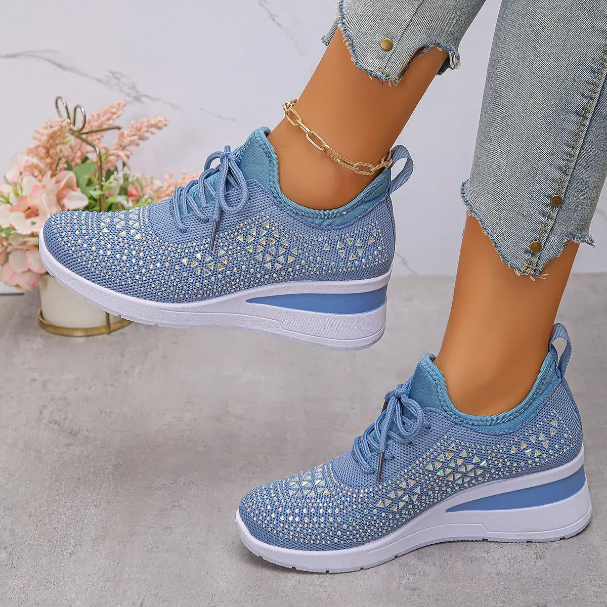 Blue patterned sneakers worn with light blue jeans on a neutral background