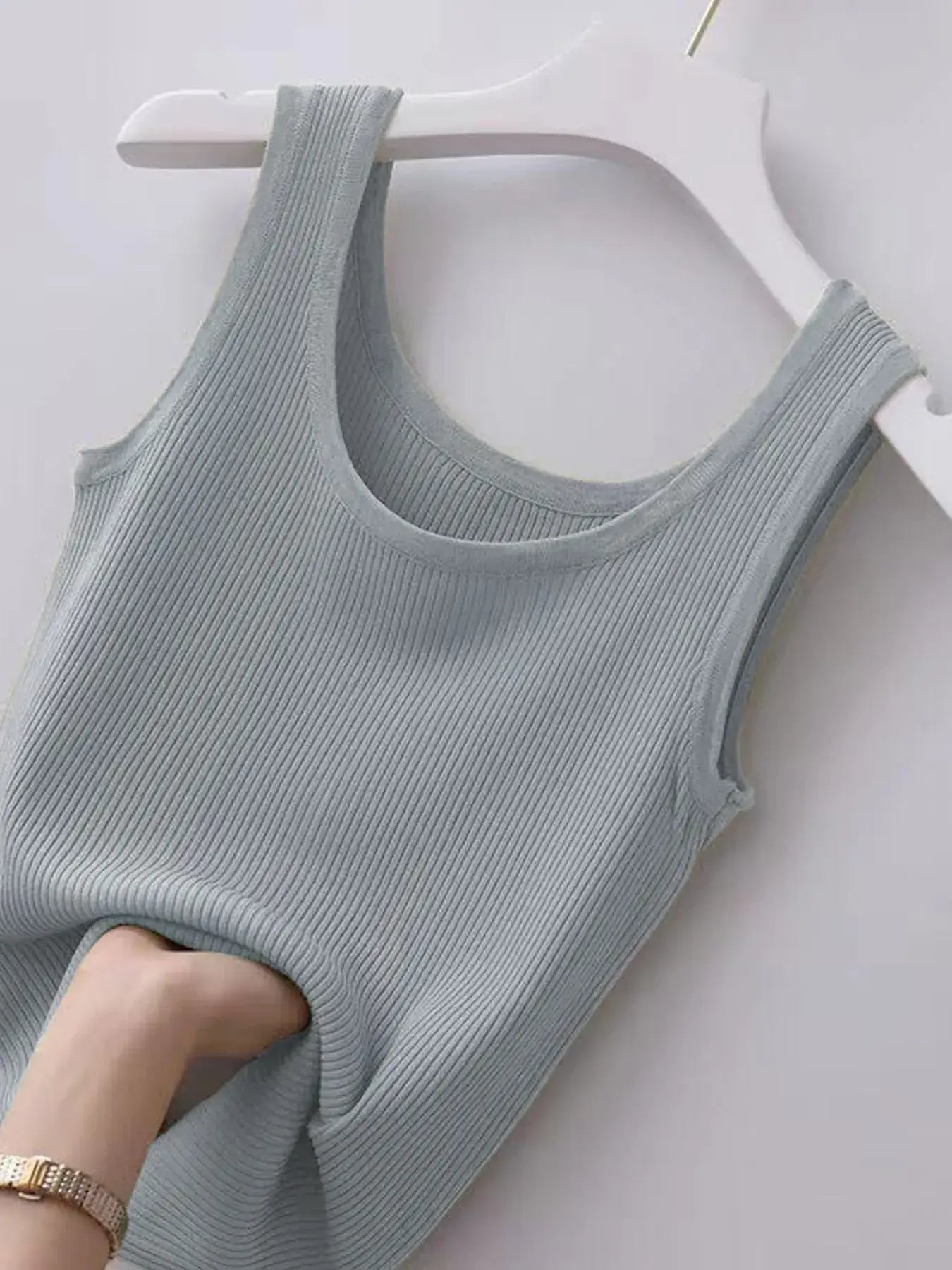 Light blue ribbed tank top on a white hanger against a white background