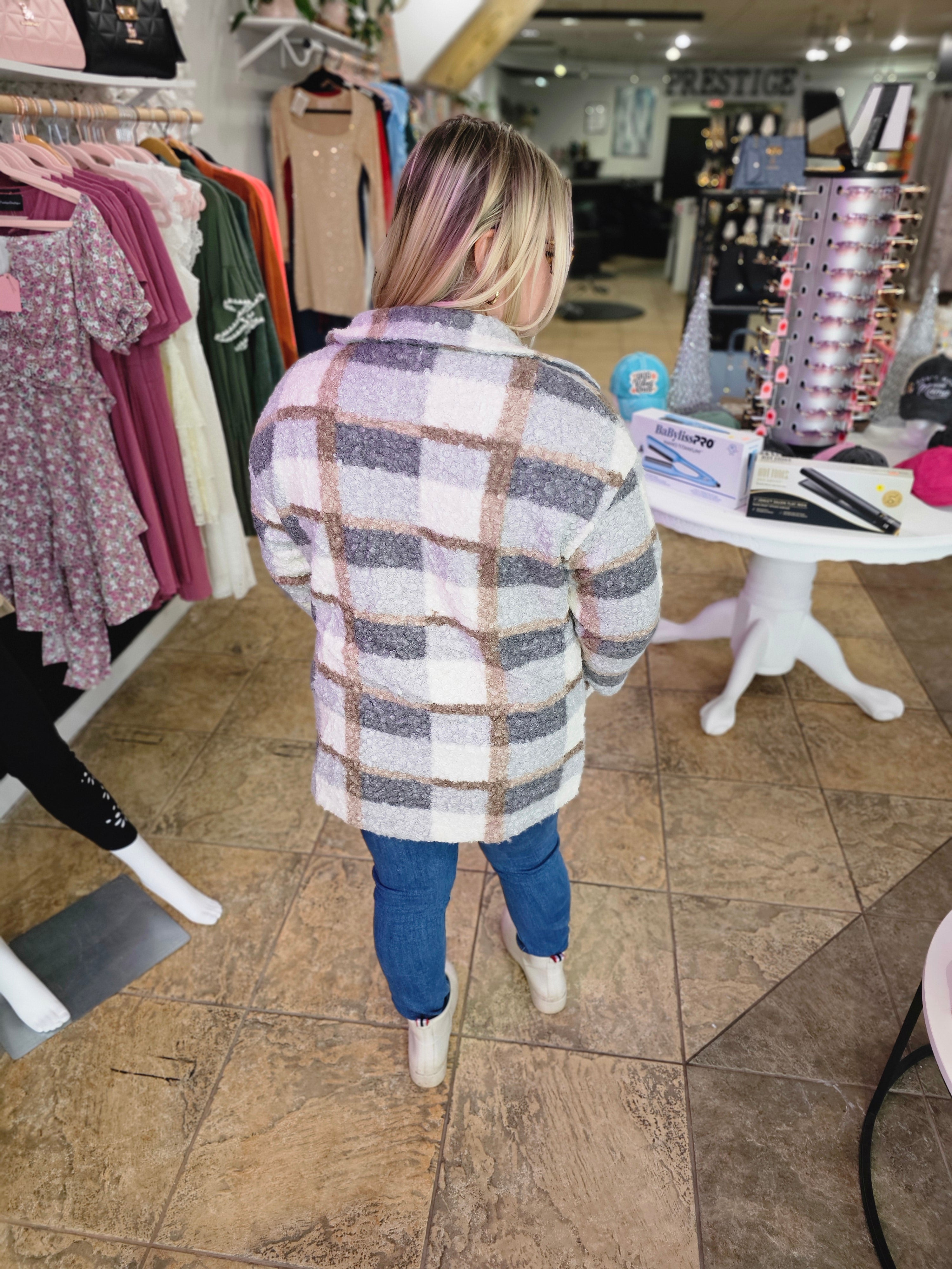 Plaid Woolen Coat featuring a chic plaid pattern in soft tones, showcased from the back in a boutique setting.