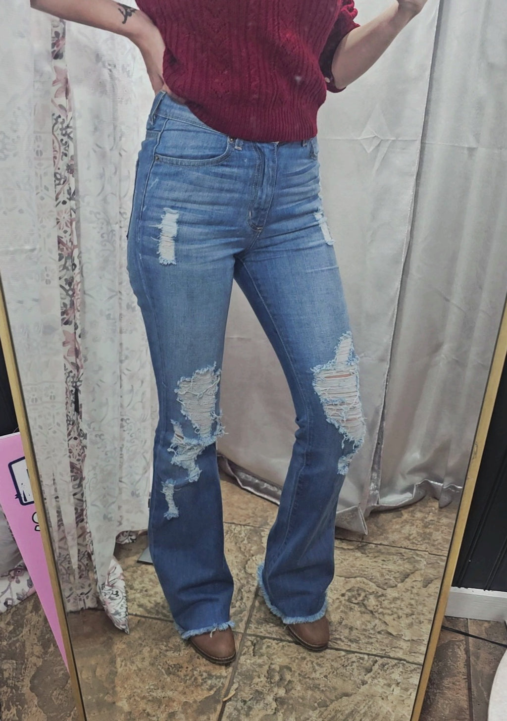 Model wearing Premium USA Denim Bootcut High Rise Jeans with distressed details in a mirror reflection.