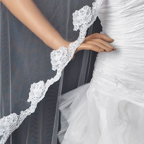 Single layer cathedral veil draped elegantly, featuring floral pearl embroidery along the edge, ideal for modern and vintage weddings.
