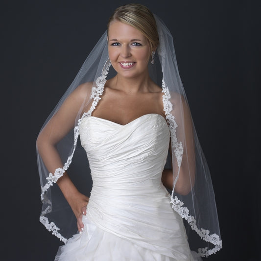 Elegant bride wearing an ivory lace embroidered fingertip-length wedding veil with rhinestones.
