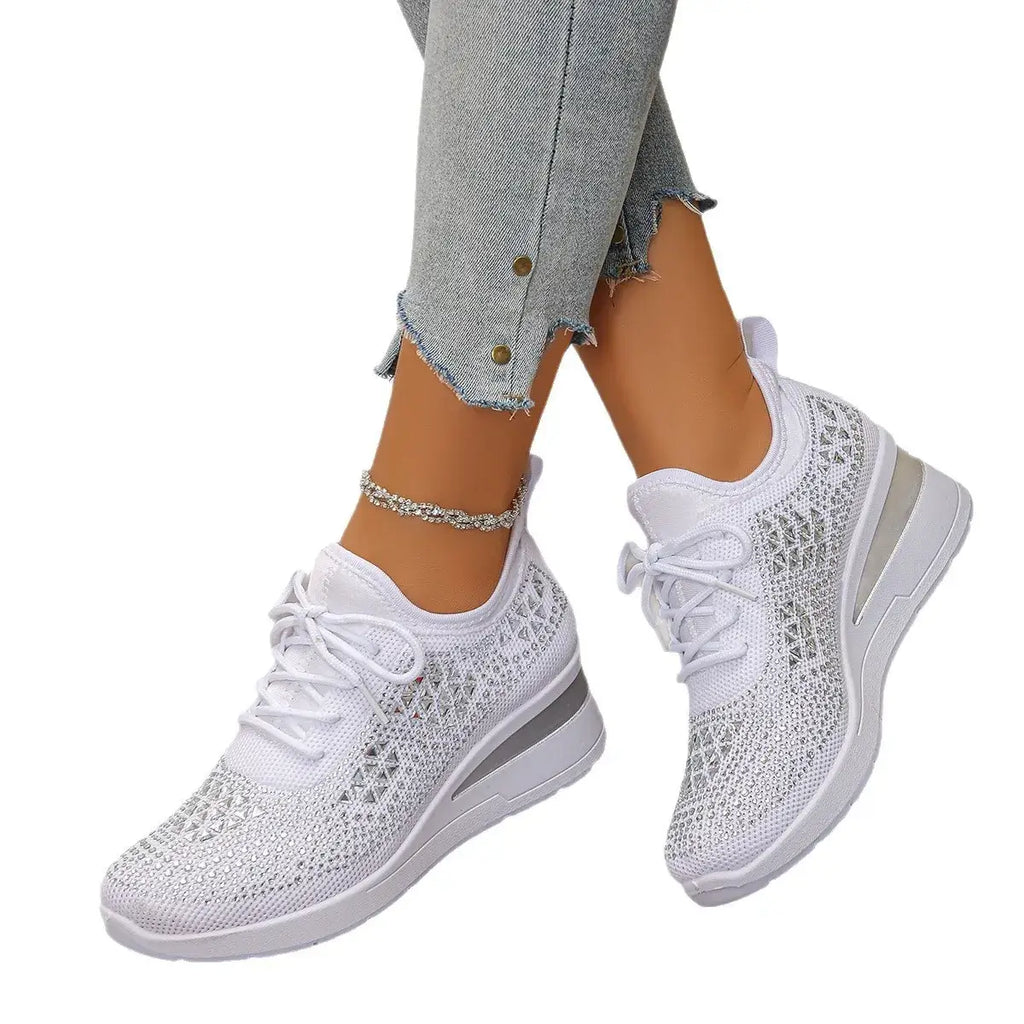 White sneakers worn with light blue jeans on a white background