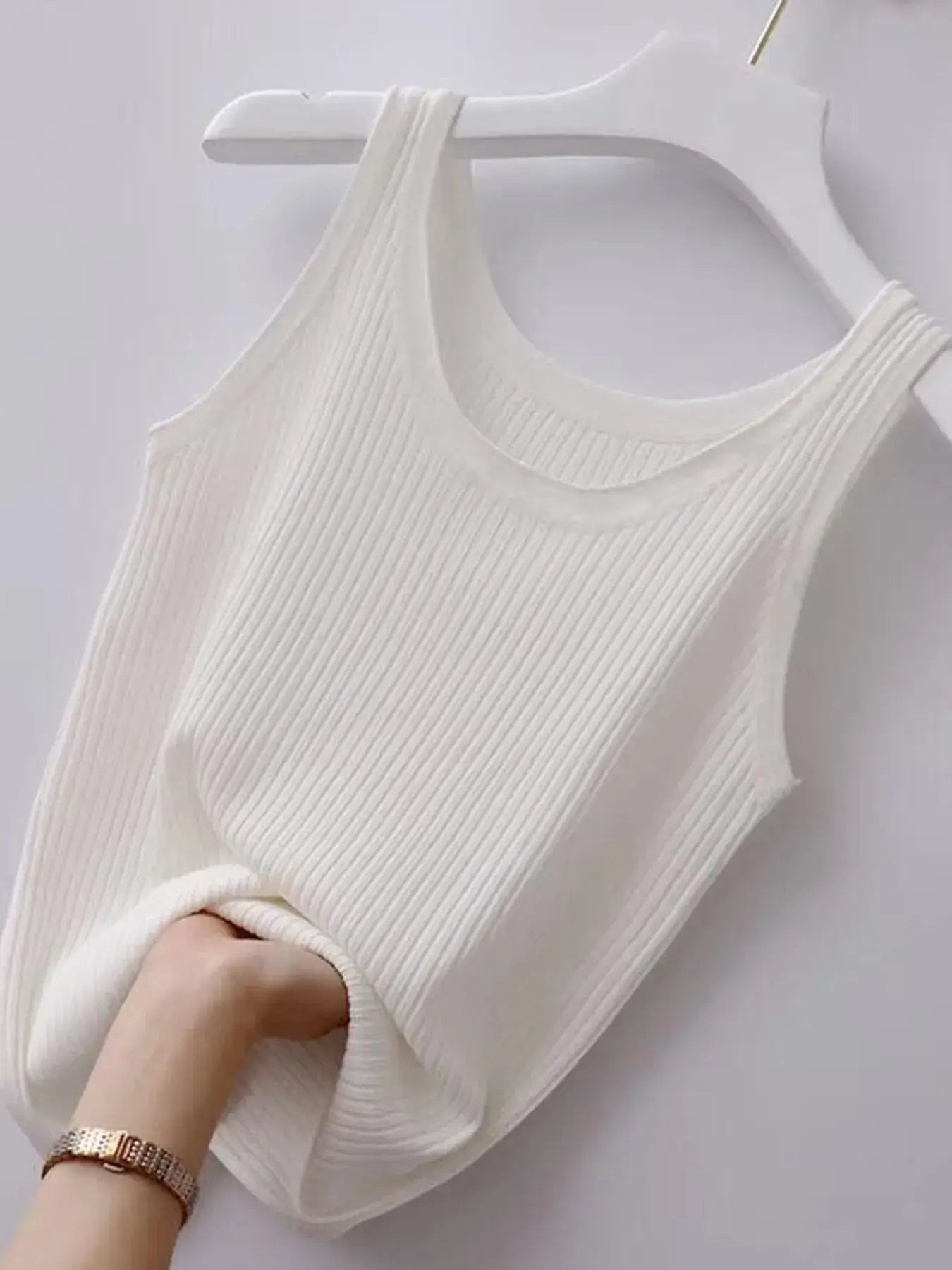 White ribbed tank top on a white hanger against a white background